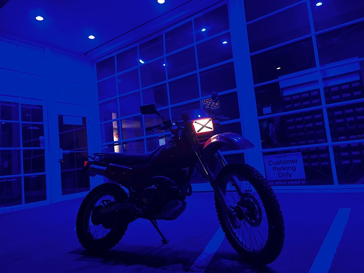 1985 Honda XL350R dual-sport motorcycle lit in blue at night